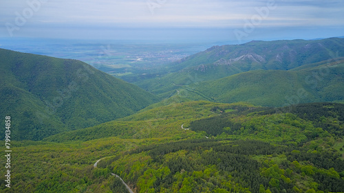 Dirt roads in the forests amidst the mountains seen from above. Aerial photo taken from a drone.