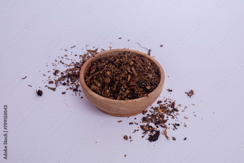 Tobacco granules in a wooden bowl on a white background. Tobacco granules in a wooden bowl on a white background.