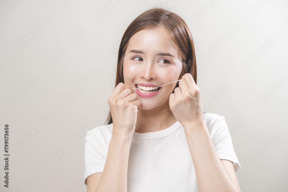 Flossing teeth, dental care hygiene concept, asian young woman flossing teeth with dental floss, smile happy with perfect white teeth, using tooth floss cleaning, healthy teeth isolated on background.