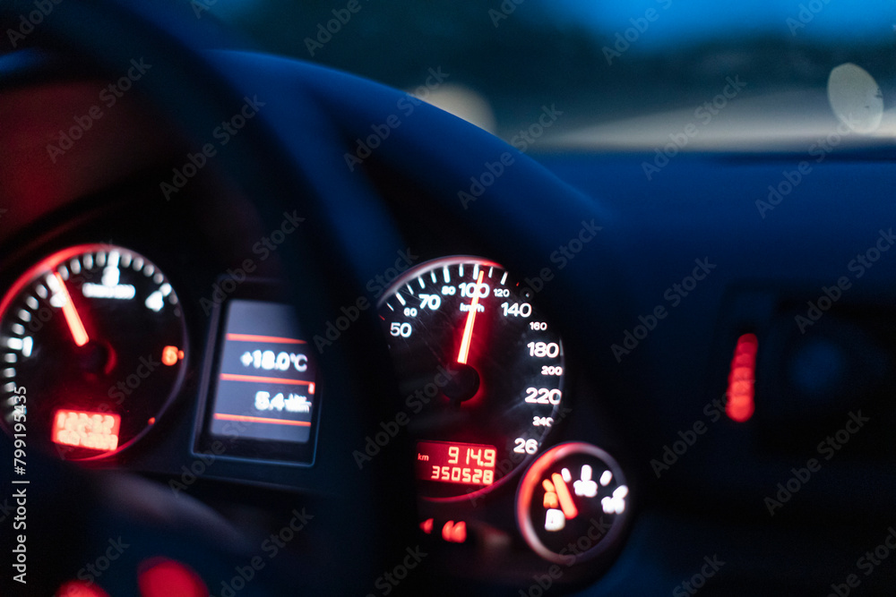 Car speedometer shows 100 kmph - driving at night