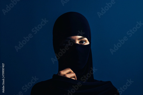 Scarf covering Woman head against a dark blue background is hiding a secret 