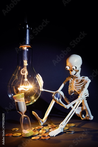 A man, a light bulb, electricity and an hourglass symbolizing the passage of time and the high cost of living. Free space for text