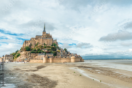 Mont Saint Michel abbey on the island during low tide, Normandy, Northern France, Europe. Tidal island with medieval gothic cathedral in Normandie. Travel and touristic destination photo