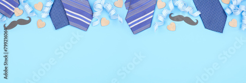 Fathers Day top border of gifts, decor, ties and ribbon. Above view on a blue banner background. Copy space.
