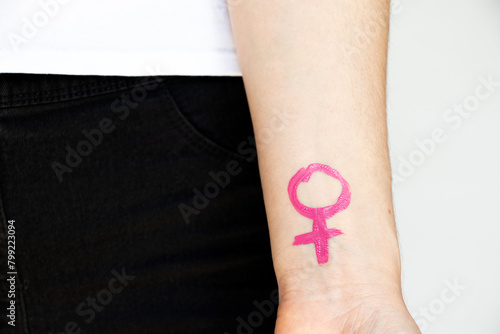 Hand drawn with pink paint gender female sign on a girl's hand