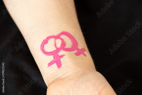 Hand drawn with pink paint gender female sign on a girl's hand