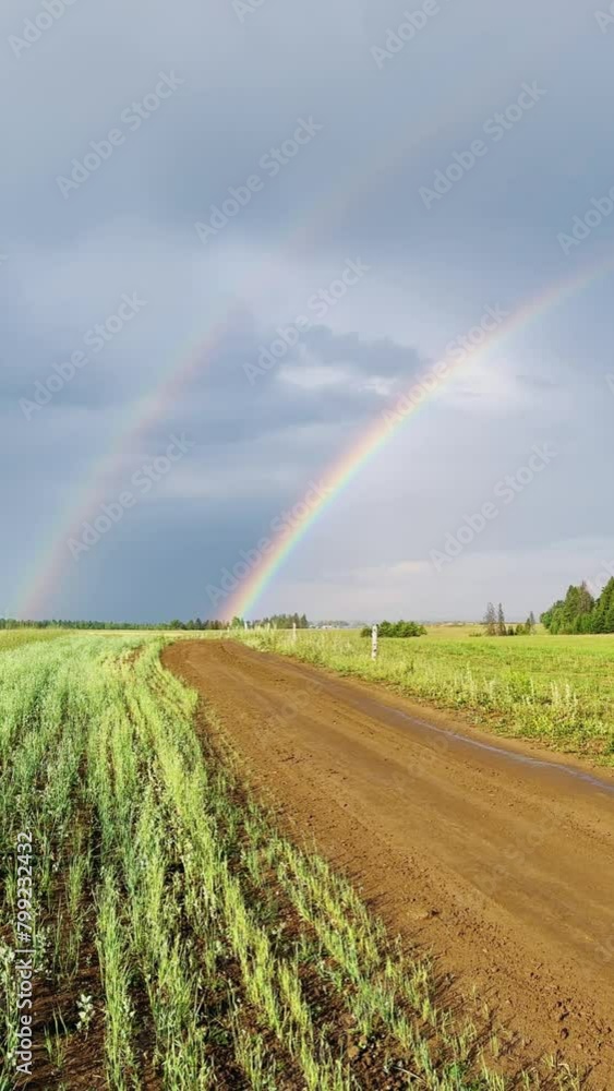 A double rainbow on a rainy spring day. A multicolored rainbow over a floral green field in the Perm Region. A rainbow against a cloudy sky. A double rainbow on a rainy spring day. A multicolored rainbow over a floral green field in the Perm Region. A rainbow against a cloudy sky.