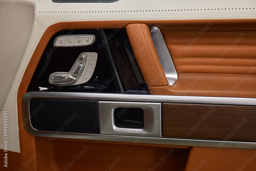 Closeup of car door with brown leather, silver trim Closeup of car door with brown leather, silver trim