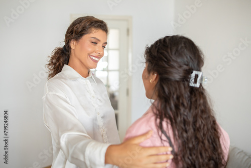 Beautiful smiling woman greeting client at her office