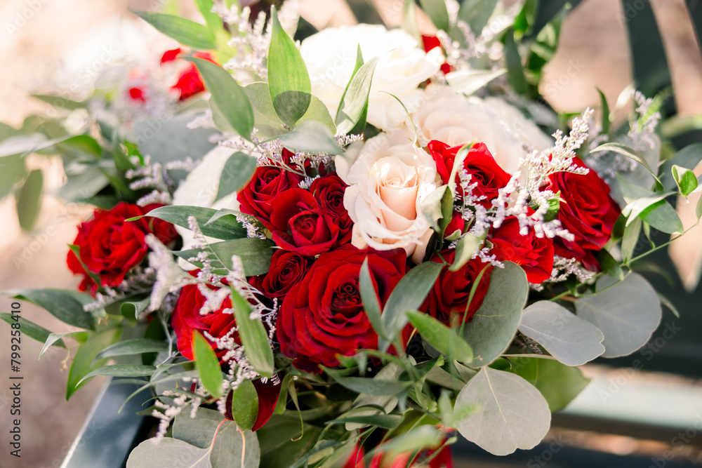 A beautiful bouquet with red and pink blush roses and eucalyptus leaves and greenery 