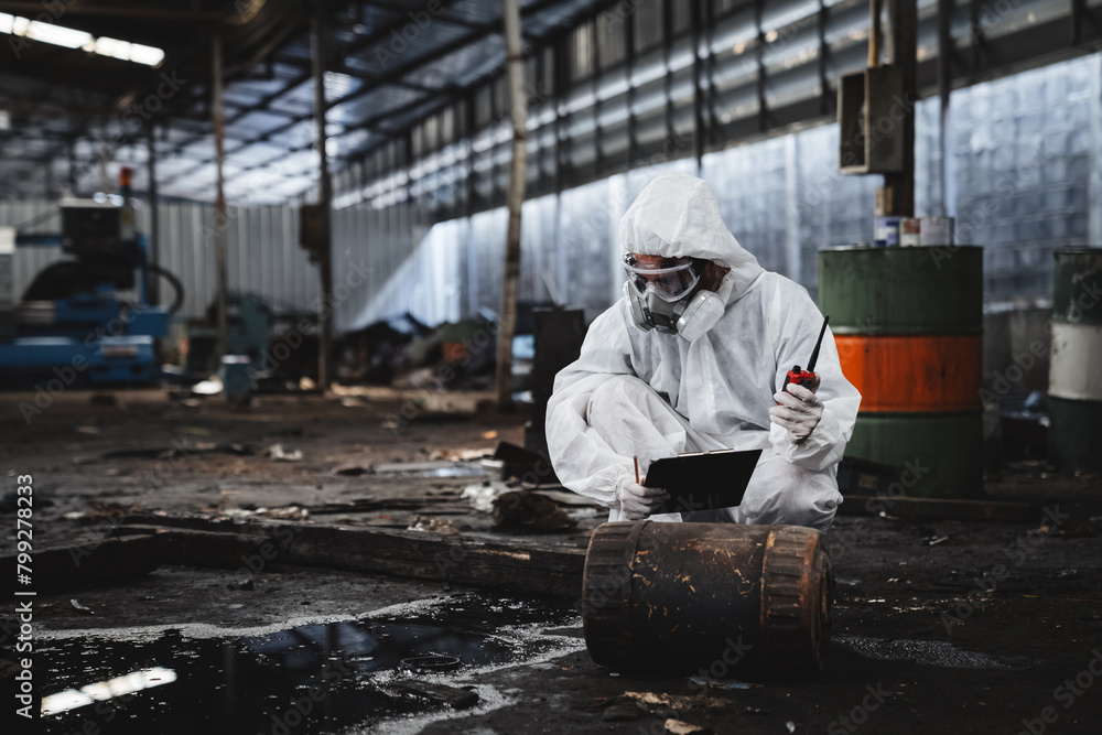 Workers in protective suits inspect chemicals in an old factory, safeguarding against hazards and contamination. This is part of an emergency response to a radioactive accident.