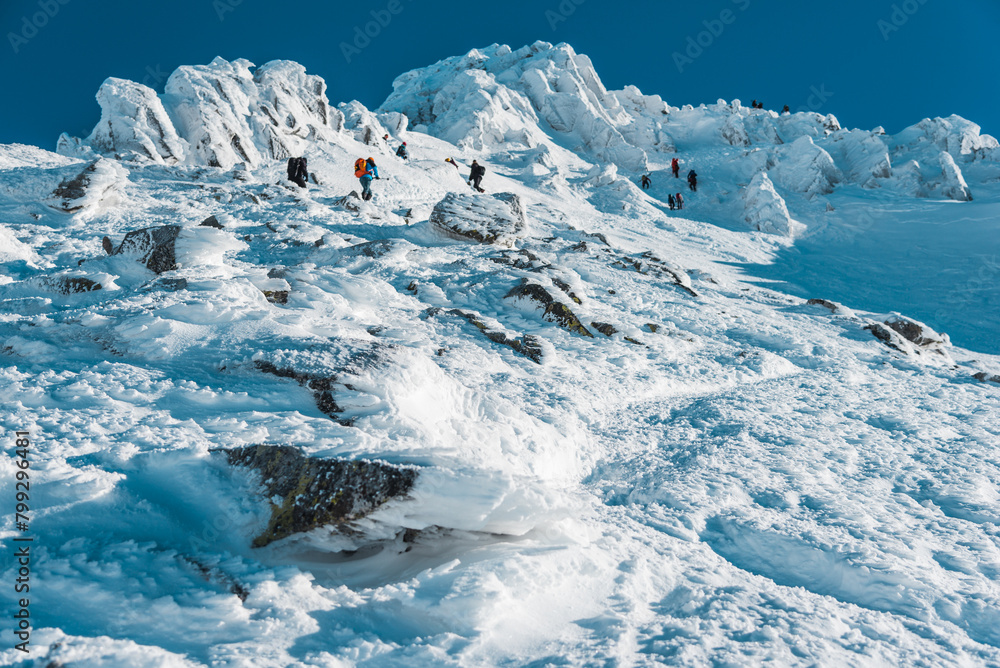 Tourists climb to the peak in winter, Tatra Mountains, Poland Tourists climb to the peak in winter, Tatra Mountains, Poland