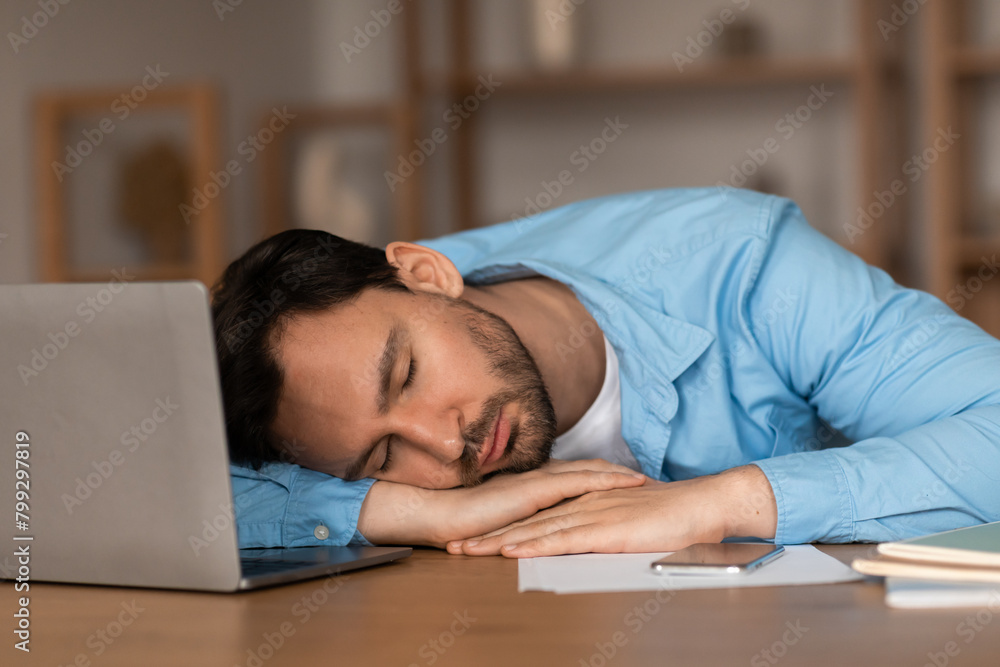 Man Sleeping on Desk Next to Laptop Man Sleeping on Desk Next to Laptop