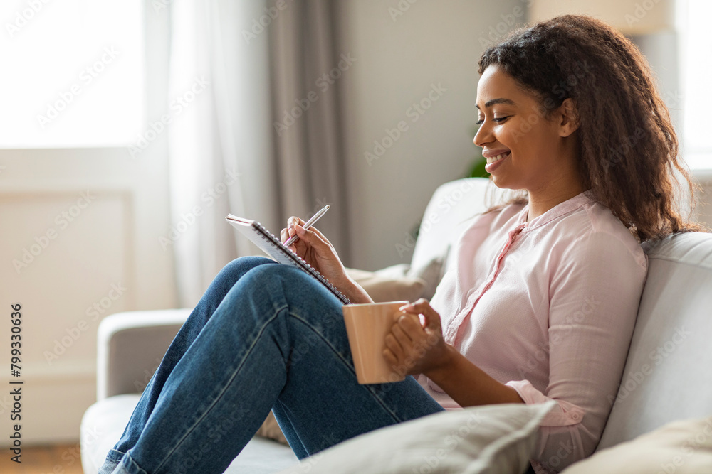 Obraz premium Joyful Moments: Young Woman Journaling with Coffee at Home
