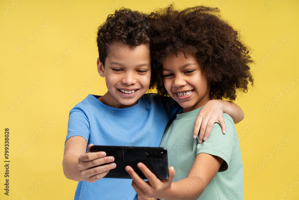 Happy African American friends holding mobile phone, using mobile app, watching video Happy African American friends holding mobile phone, using mobile app, watching video
