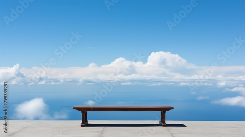 Empty bench overlooking a serene ocean view under a clear blue sky