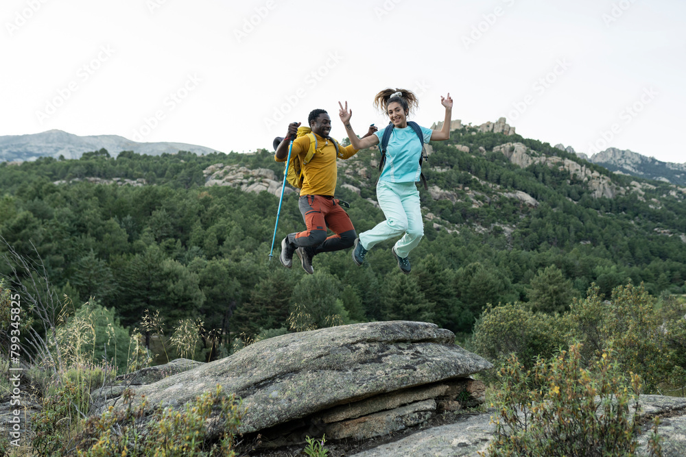 Joyous Couple Celebrating with a Leap in the Mountains