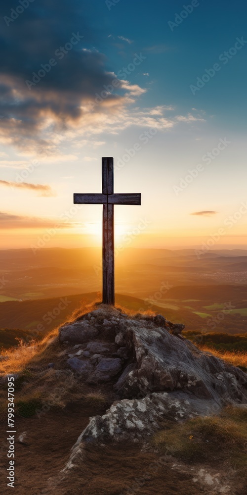 Sunset behind a cross on a mountain summit