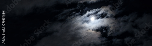 Night sky with moon and mystic clouds, panoramic scary dark gothic background. Concept of horror, Halloween, spooky space
