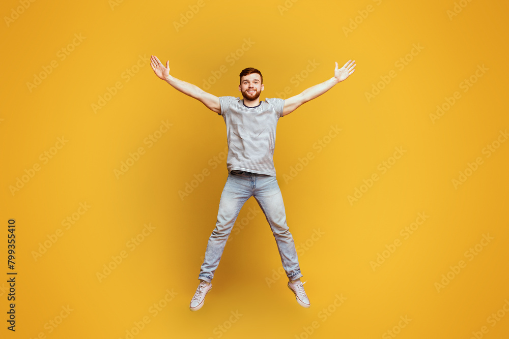 Energetic Man Jumping With Arms Outstretched