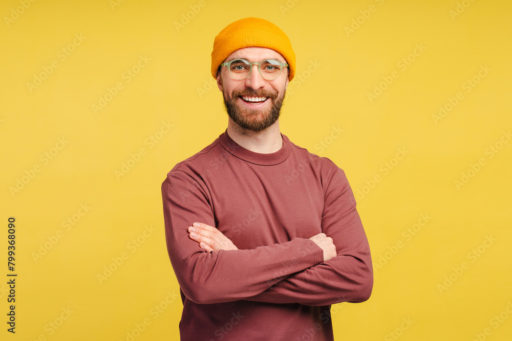 Smiling handsome bearded man, hipster looking at camera and posing arms crossed