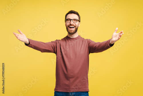 Happy friendly man in eyeglasses holding arms open ready for hugs isolated