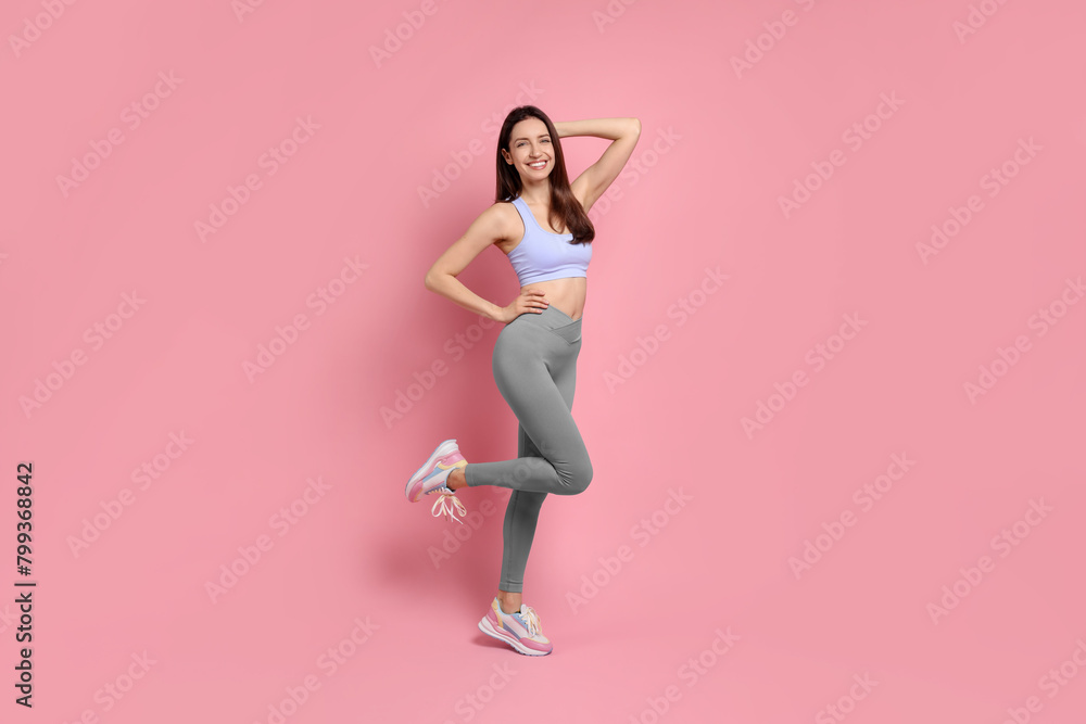 Happy young woman with slim body posing on pink background Happy young woman with slim body posing on pink background