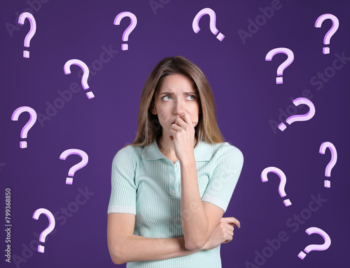 Amnesia. Confused young woman and question marks on purple background