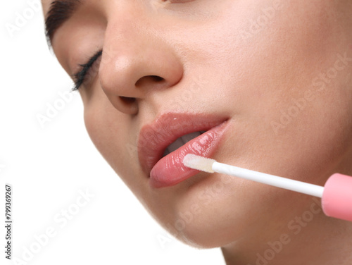 Woman applying lip gloss on white background  closeup