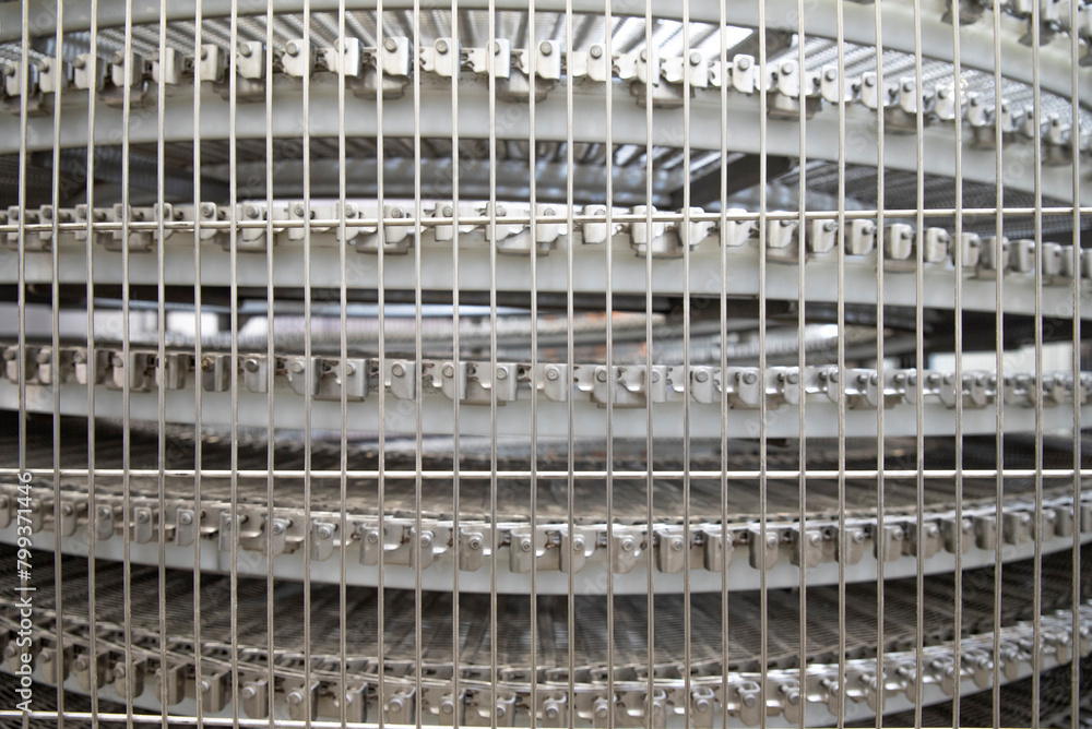Conveyor belt behind a metal mesh Conveyor belt behind a metal mesh