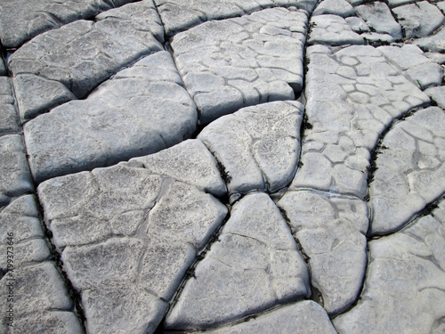 close up detailed shot of grey cracked rock formations on a beach in Somerset England