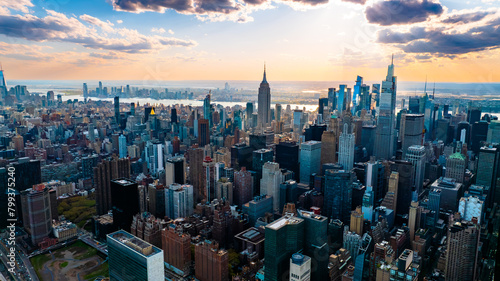 Skyline of modern New York, the USA. Majestic skyscrapers on the waterfront under the cloudy sky at daytime.