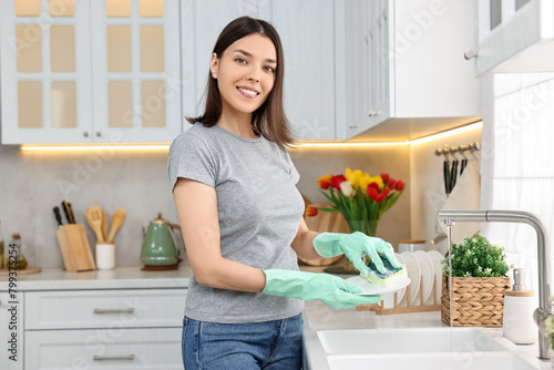 Woman washing dishes in kitchen sink. Cleaning chores