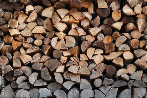 Stack of split raw wood logs as fuel for heating. Firewood pattern background