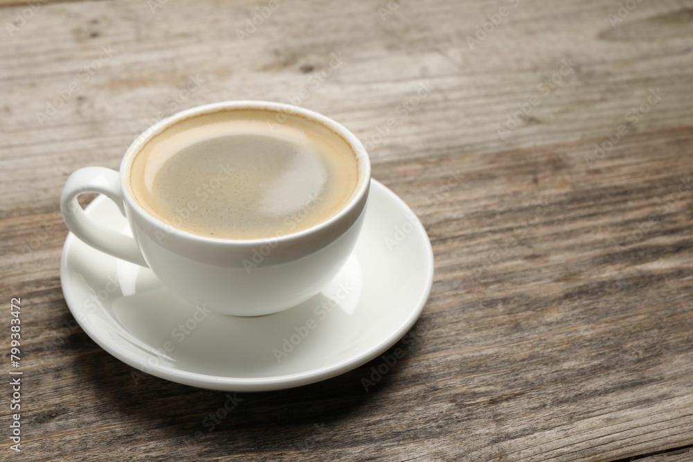 Aromatic coffee in cup on wooden table. Space for text Aromatic coffee in cup on wooden table. Space for text