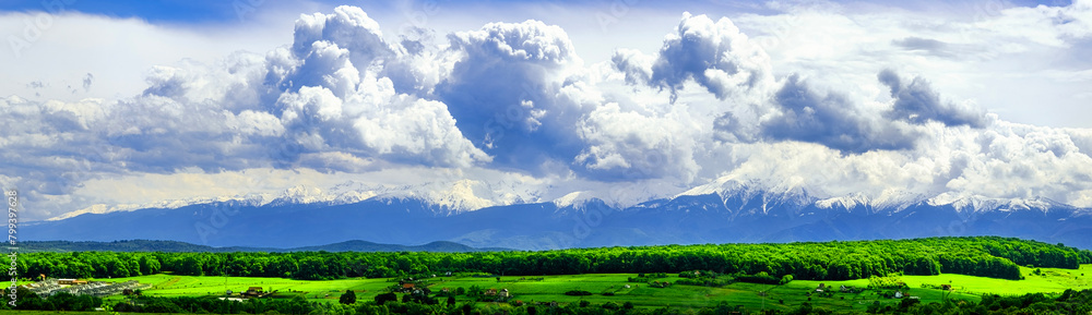Panoramic spring view of the famous Romanian mountains Fagaras with snow and green grass Panoramic spring view of the famous Romanian mountains Fagaras with snow and green grass