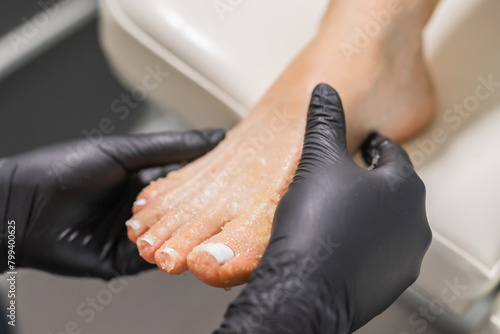 Peeling feet pedicure procedure in a beauty salon. Sugar scrub and relax beauty procedure © satura_