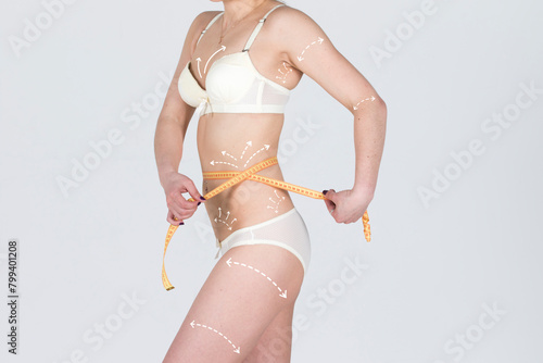 Cellulite removal on body perfect girl. Young woman with meter, on body. Plastic surgery concept.