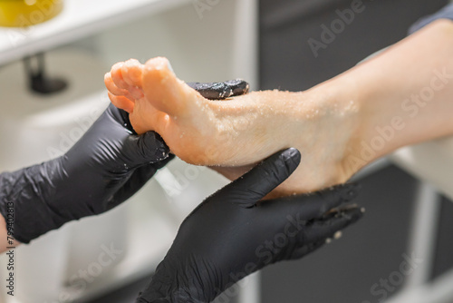 Peeling feet pedicure procedure in a beauty salon. Sugar scrub and relax beauty procedure