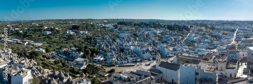  Aerial drone view of Beautiful stone Trulli houses with narrow streets in village of Alberobello. Picturesque village on a hill in Apulia, southern italy.  photo