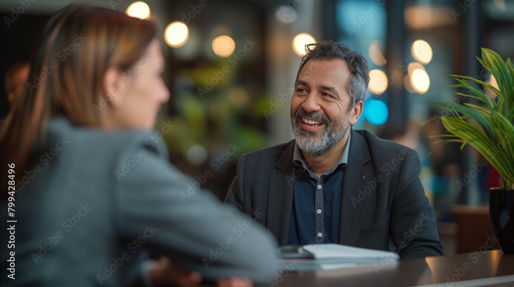 Happy hotel manager talking to guest at reception