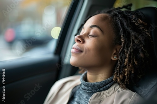A side view of a thoughtful African American woman with dreadlocks enjoying a peaceful moment looking out of a car window © ChaoticMind