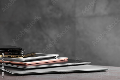 Many different modern gadgets on grey table, closeup. Space for text