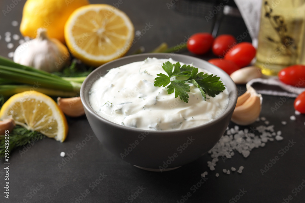 Delicious yogurt in bowl and ingredients on black table, closeup Delicious yogurt in bowl and ingredients on black table, closeup