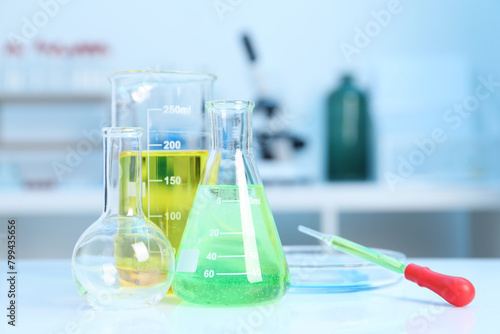 Laboratory analysis. Different glassware with liquids on white table indoors