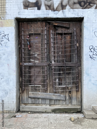 old boarded up door with iron bars and a tied Voodoo doll