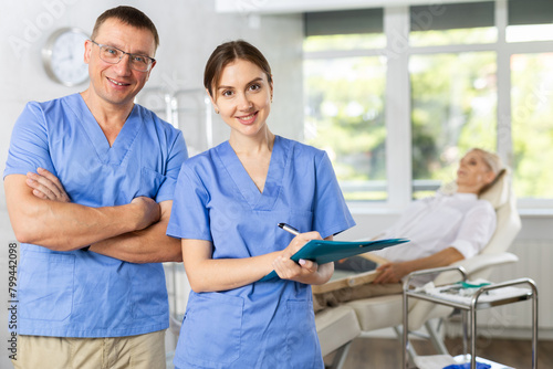 Doctors or surgers with paper board or patient folder (OPD) looking at camera. photo