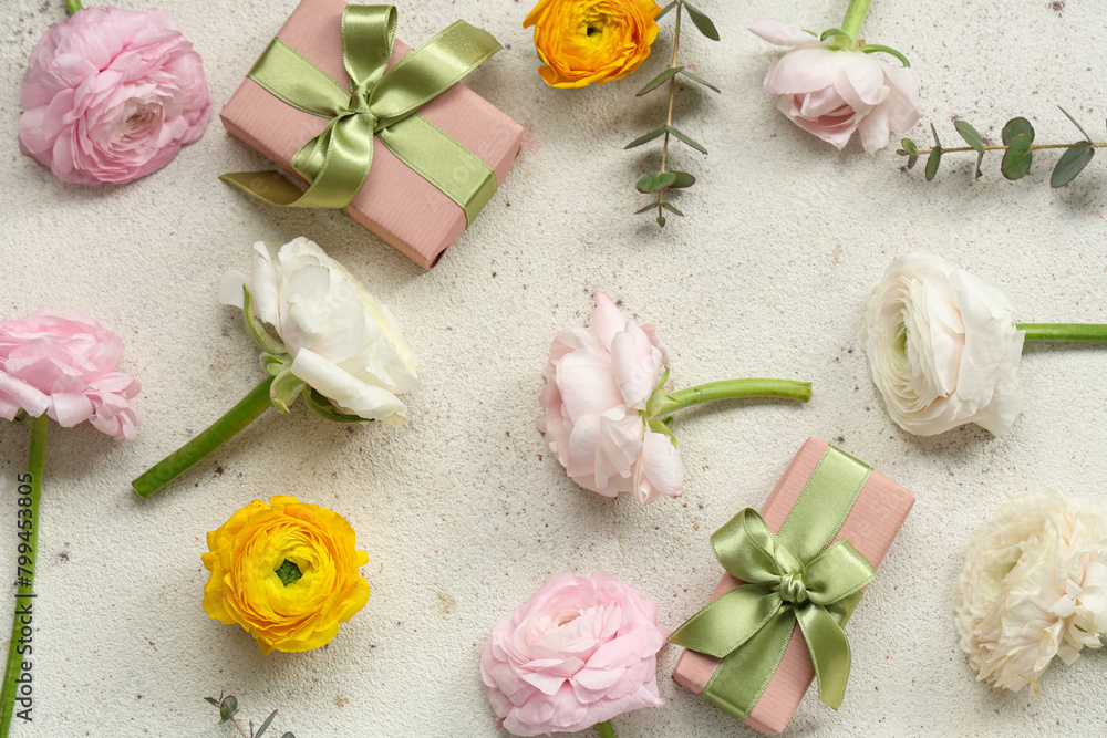 Beautiful ranunculus flowers with eucalyptus and gift boxes on white grunge background Beautiful ranunculus flowers with eucalyptus and gift boxes on white grunge background