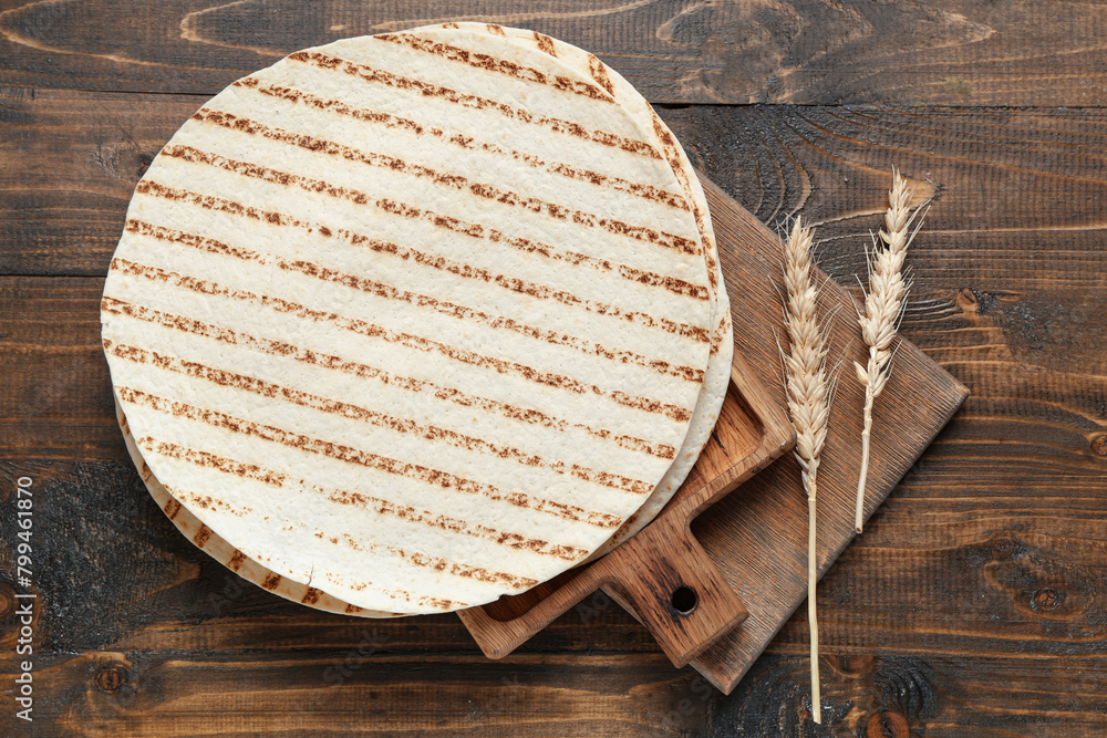 Composition with fresh lavash and cutting board on wooden background Composition with fresh lavash and cutting board on wooden background