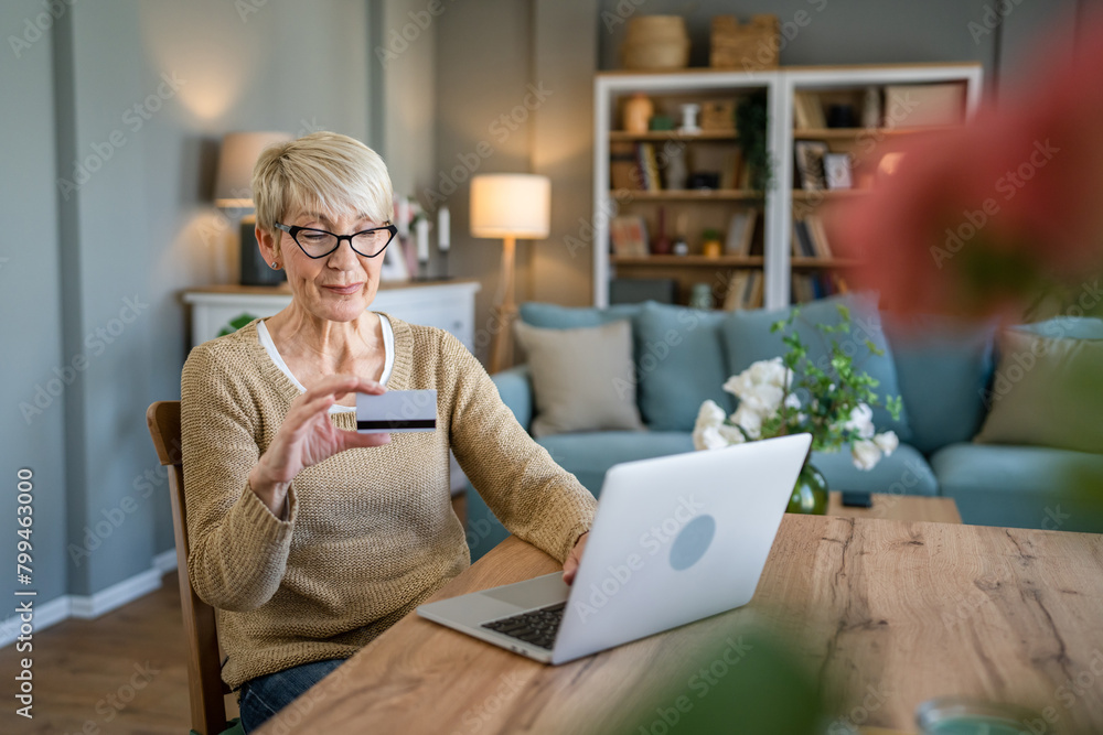 Senior woman caucasian female hold credit card online shopping at home Senior woman caucasian female hold credit card online shopping at home